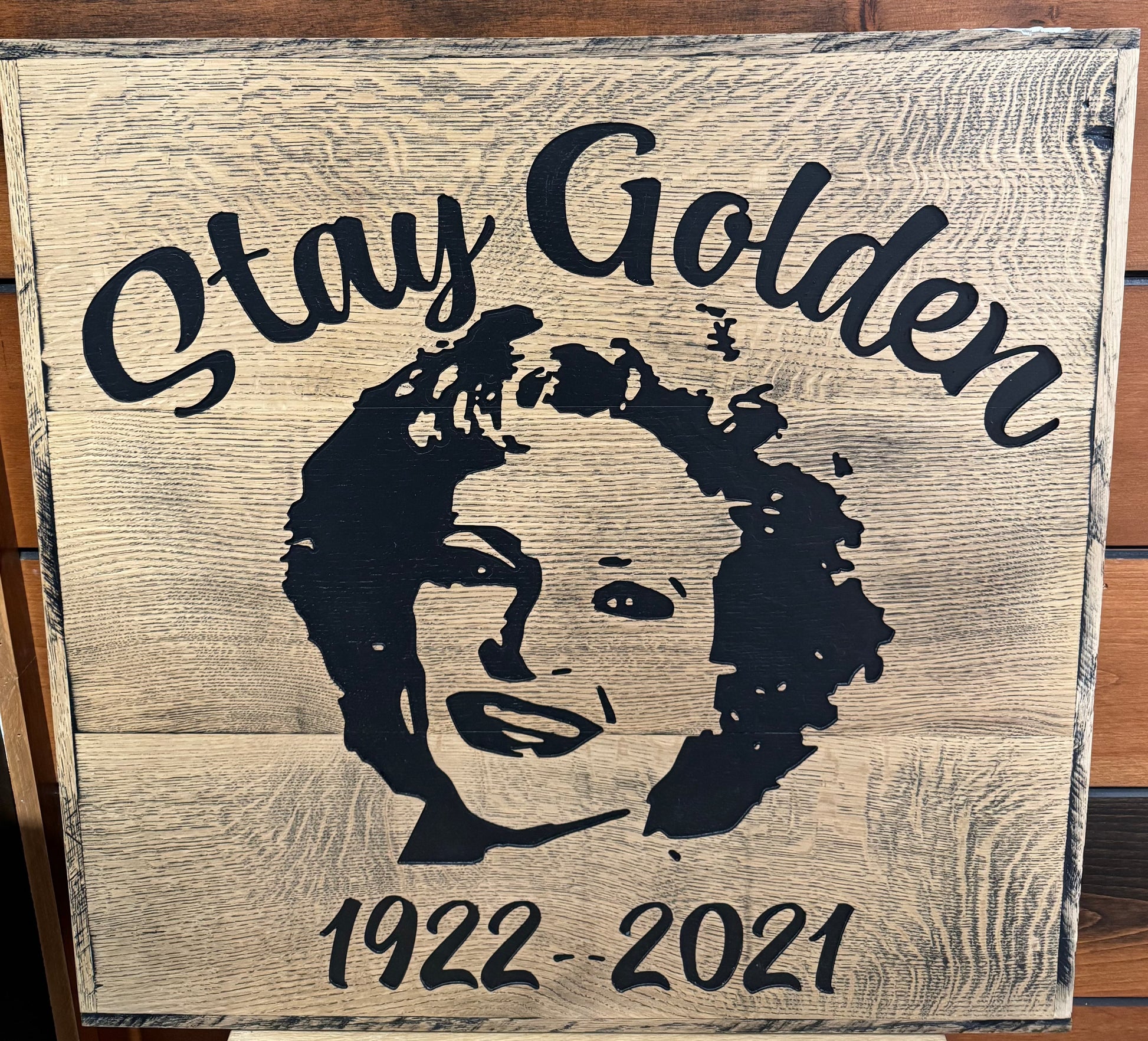 Wooden sign with image of Betty White smiling in the center. Stay Golden is written across the top. 1922-2021 is written at the bottom.